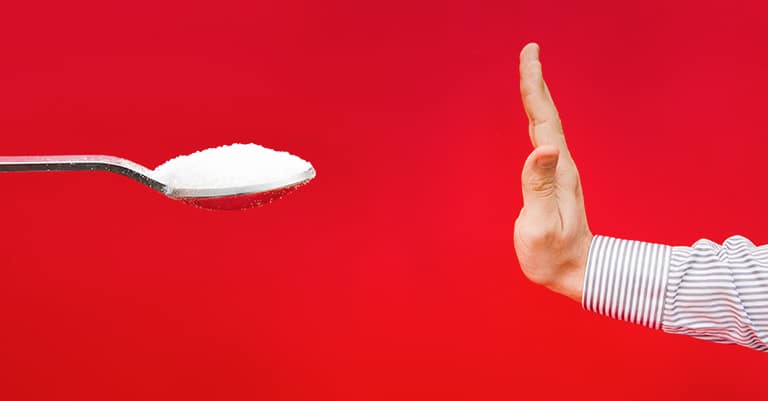 A spoon of sugar opposite a hand indicating stop, over a red background